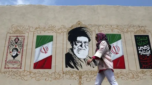 امرأة تسير أمام جدارية في طهران، إيران، في 6 أغسطس/آب 2026، في ظل استمرار الحياة اليومية وسط التوترات المتصاعدة بين الولايات المتحدة وإيران
