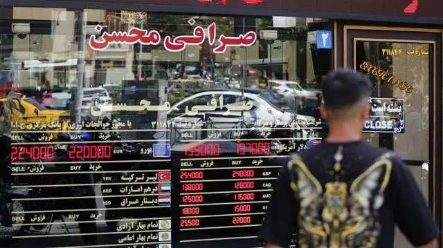 إيراني يعاين أسعار الصرافة