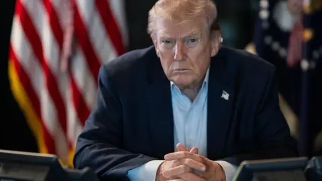 ترامب يحدق في الكاميرا بنظرات حادة من مكتبه البيضاوي بدون رابطة عنق