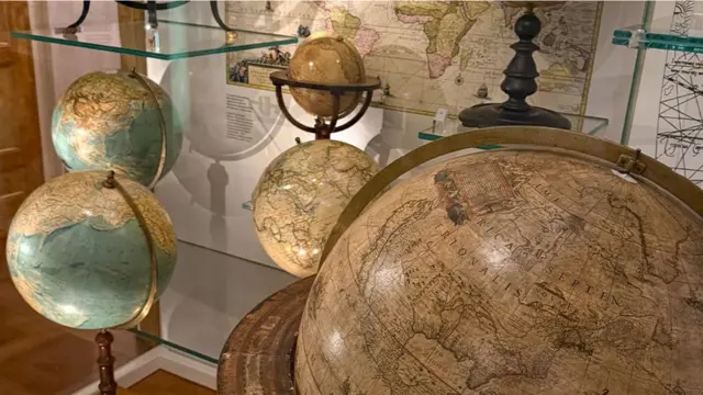 مجسمات قديمة بأحجام مختلفة للكرة الأرضية في أحد غرف المتحف
